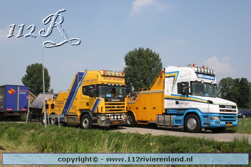 Vrachtauto met oplegger gekanteld