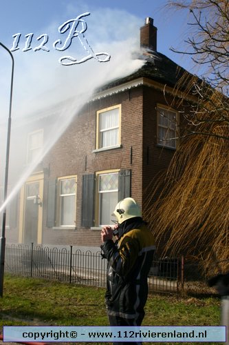 Woning met rietekap in de brand