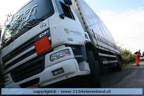 Vrachtwagen glijdt van de dijk