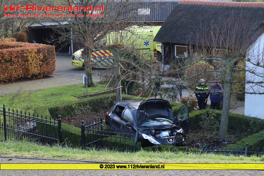 Auto van de dijk en belandt in voortuin