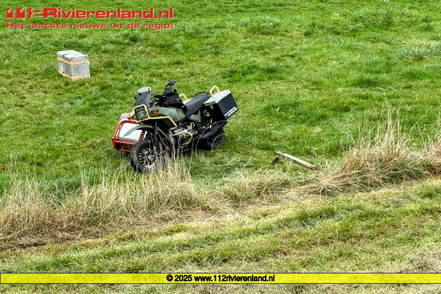 Motorrijder met zijspan van de dijk